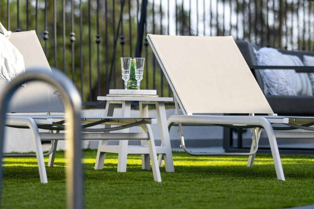 Two lounge chairs by a pool with drinks