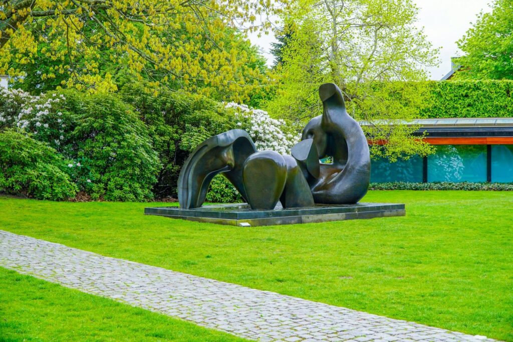 Modern sculpture in a lush green garden with a path